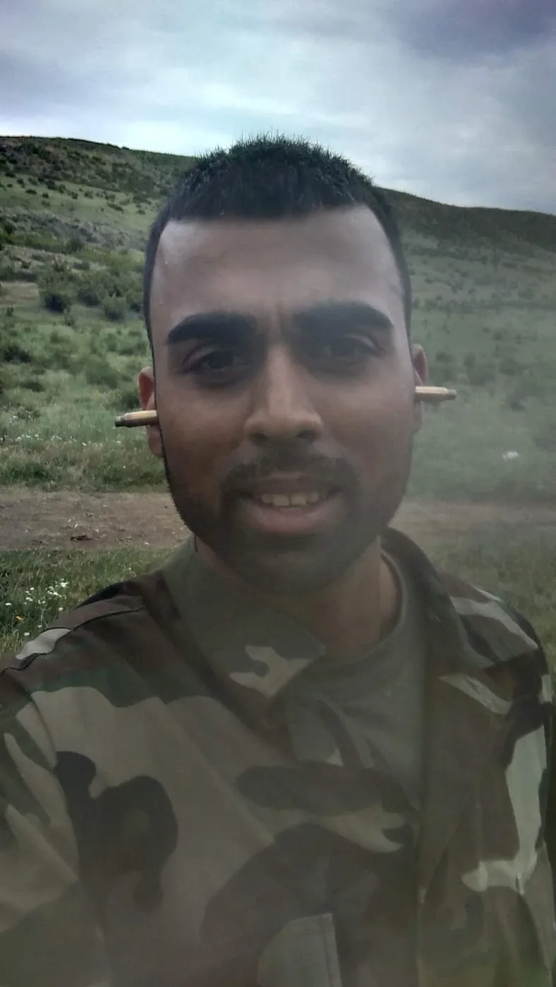 Deepak Shukla wearing camouflage uniform outdoors on open ground.