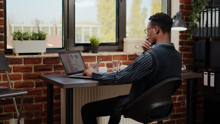 Financial consultant analyzing sales development on laptop