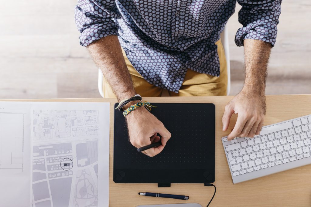 Close-up of man working at home using graphics tablet