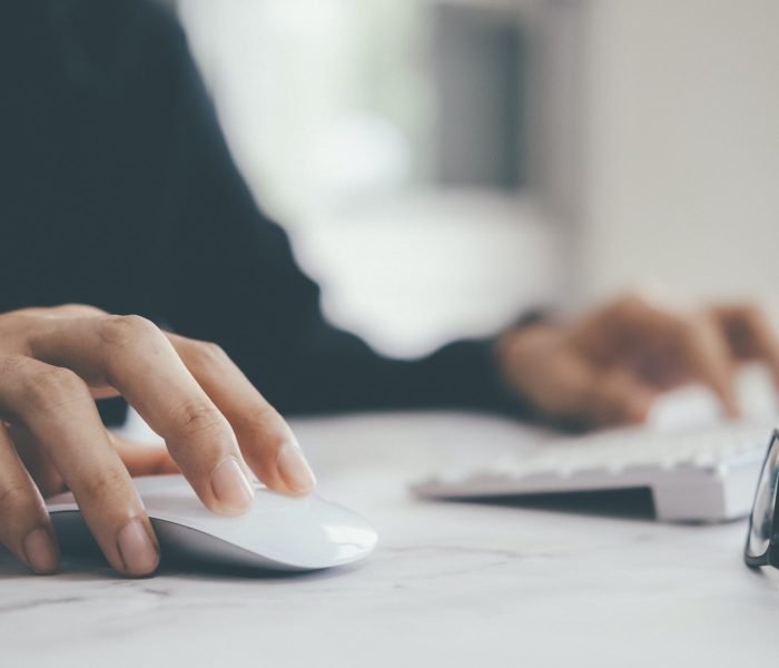 Closeup businessman using computer mouse with computer keyboard